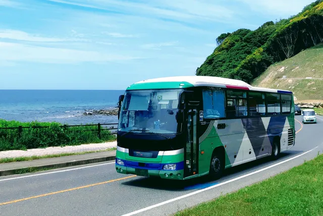 海沿いを走る貸切大型バス