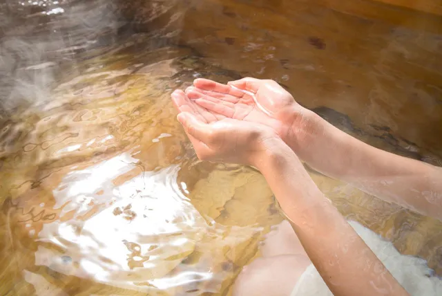 温泉を掬う女性