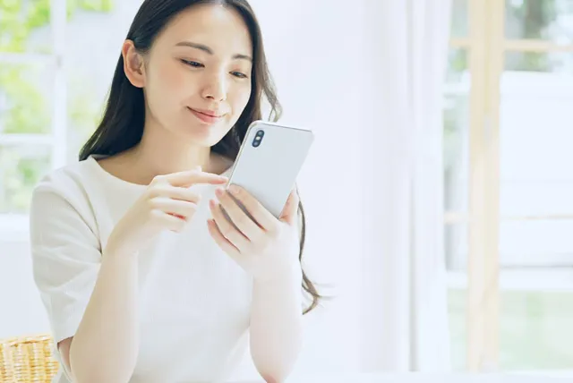 スマートフォンで予約をする女性