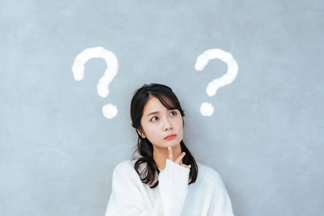 貸切バスを借りる場面が思い浮かばず考える女性のイメージ