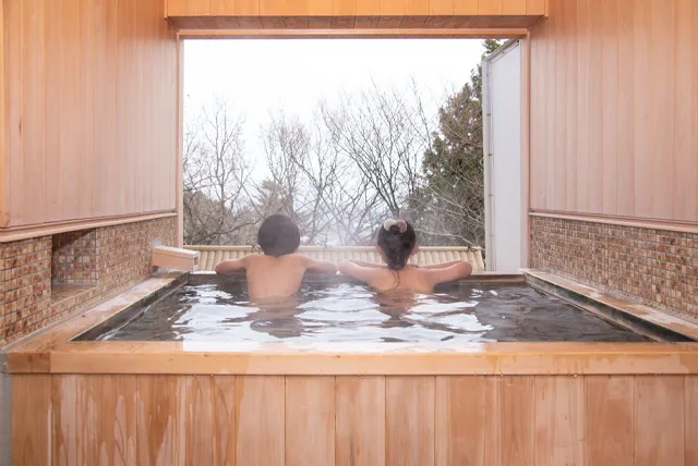 温泉宿で入浴を楽しむ団体旅行の様子（貸切バス利用イメージ）