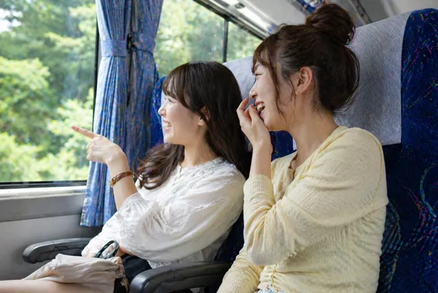 貸切バスの車内で会話や景色を楽しむ乗客の様子