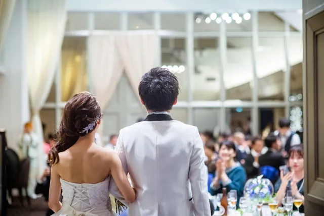 結婚式会場で集まる新郎新婦と親族の移動利用イメージ