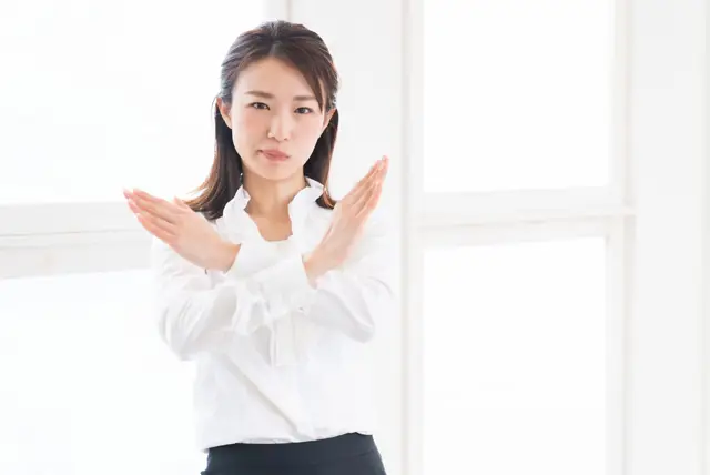 バツ印をする女性