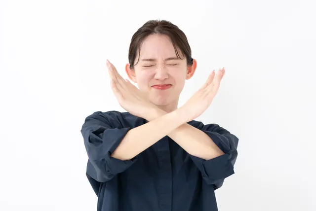 バツ印を出す女性