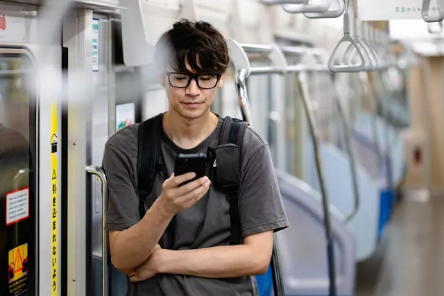 電車でキャンプ場へ向かう男性
