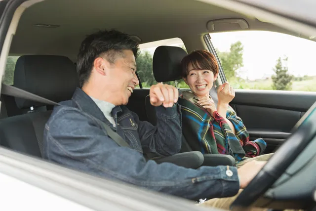 自家用車の車内で楽しそうに話す男女