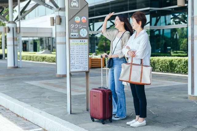 空港へ行くタクシーを待つ女性