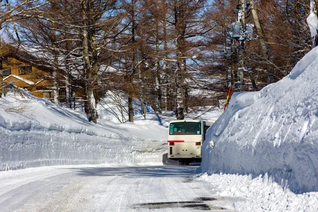 雪深い山道を走るバス
