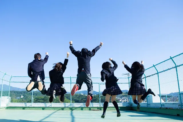 学校の屋上で記念写真を撮る高校生