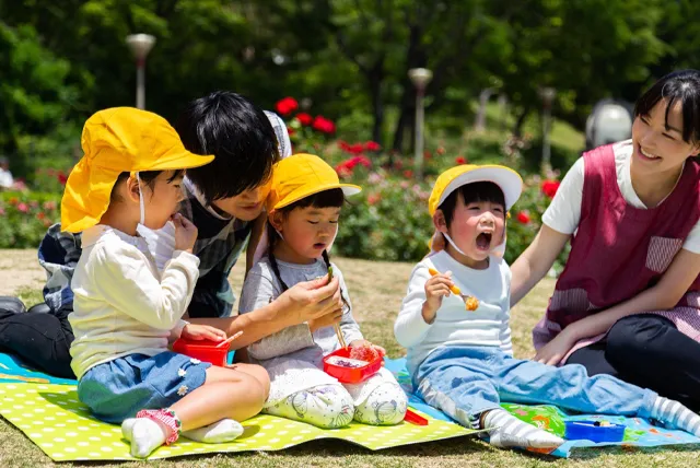 遠足でお弁当を食べる幼稚園児