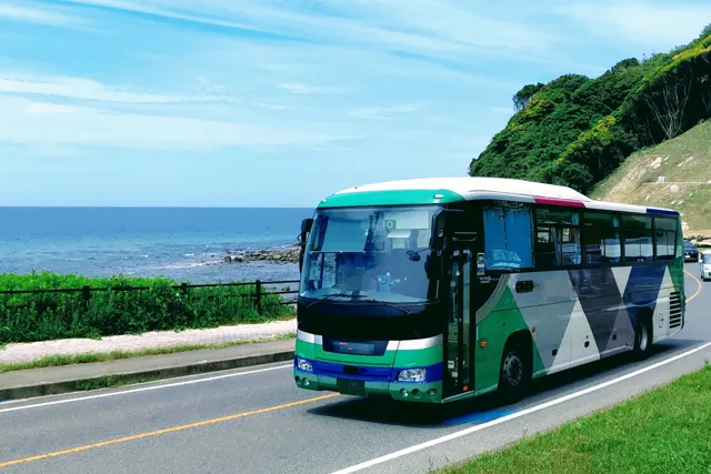 海岸線を走る貸切大型バス